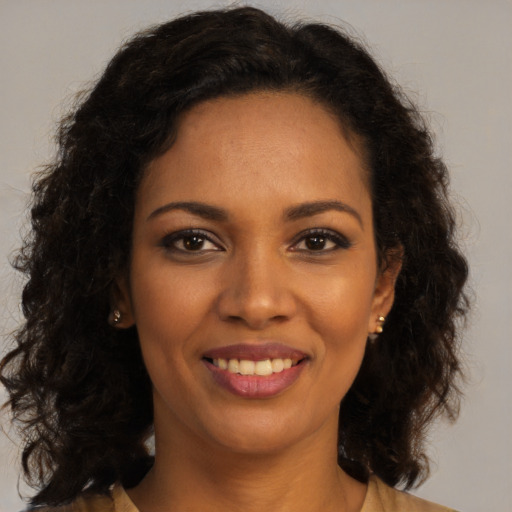 Joyful black young-adult female with long  brown hair and brown eyes