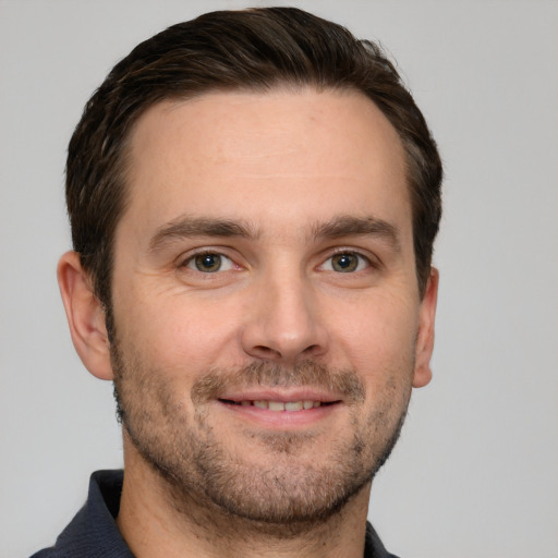 Joyful white young-adult male with short  brown hair and grey eyes