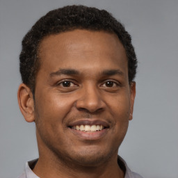Joyful latino young-adult male with short  brown hair and brown eyes