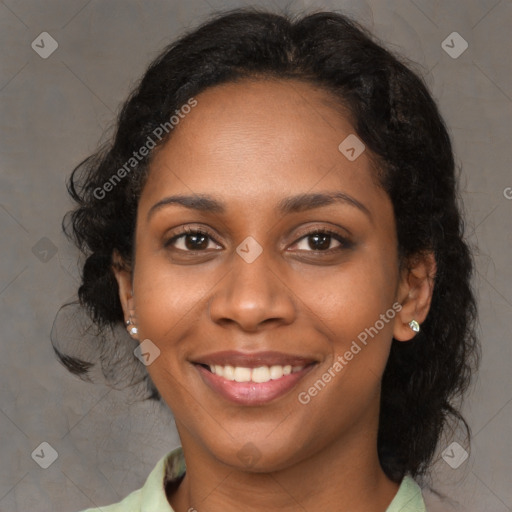 Joyful black young-adult female with long  brown hair and brown eyes