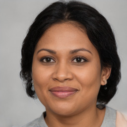 Joyful black adult female with medium  brown hair and brown eyes