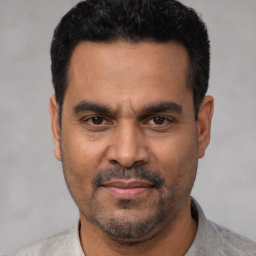 Joyful latino adult male with short  black hair and brown eyes