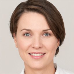 Joyful white young-adult female with medium  brown hair and grey eyes