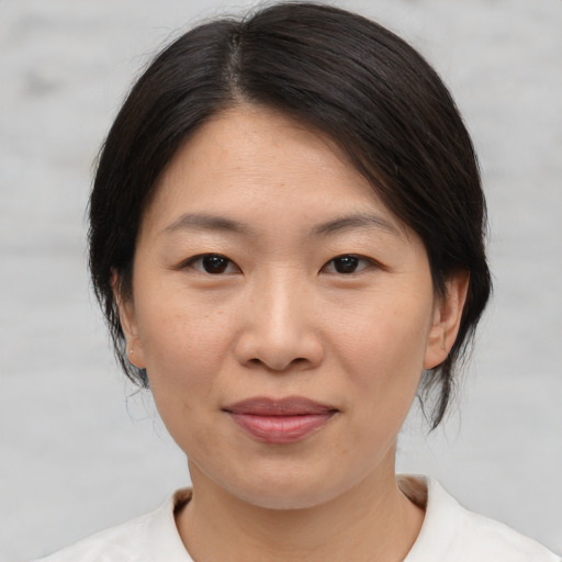 Joyful asian adult female with medium  brown hair and brown eyes