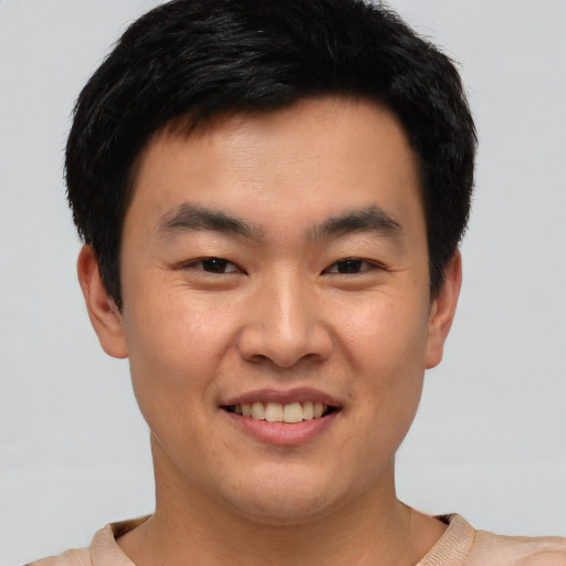 Joyful asian young-adult male with short  brown hair and brown eyes