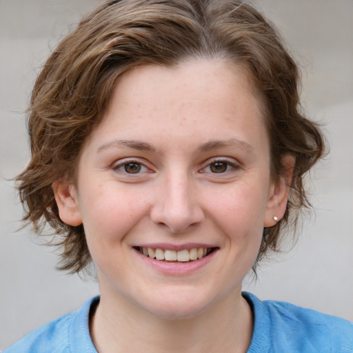 Joyful white young-adult female with medium  brown hair and blue eyes