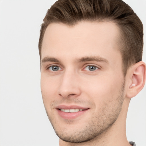 Joyful white young-adult male with short  brown hair and grey eyes