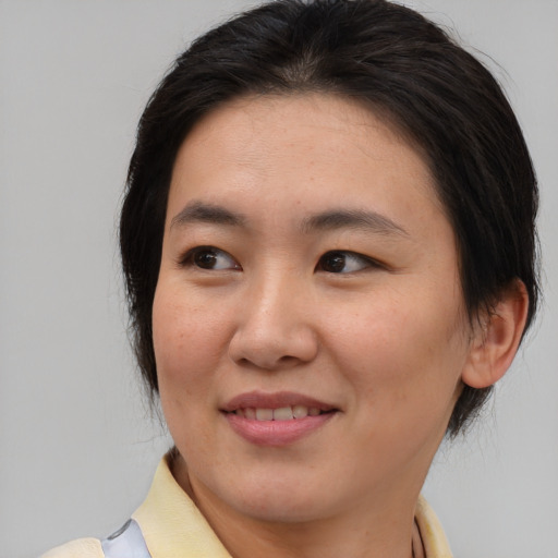 Joyful asian young-adult female with medium  brown hair and brown eyes