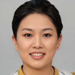 Joyful asian young-adult female with short  brown hair and brown eyes