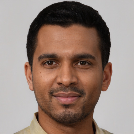 Joyful black young-adult male with short  black hair and brown eyes