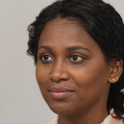 Joyful black young-adult female with medium  brown hair and brown eyes