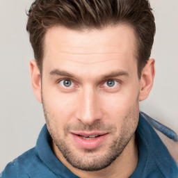 Joyful white young-adult male with short  brown hair and grey eyes