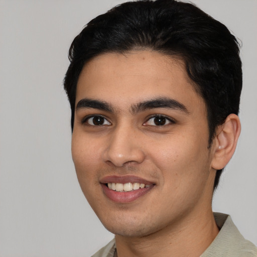 Joyful latino young-adult male with short  black hair and brown eyes