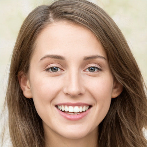 Joyful white young-adult female with long  brown hair and green eyes