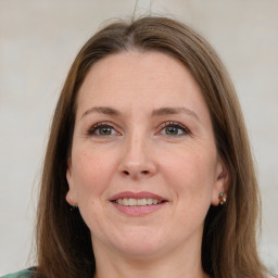 Joyful white adult female with medium  brown hair and green eyes