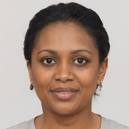 Joyful black young-adult female with short  black hair and brown eyes
