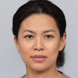 Joyful asian adult female with medium  brown hair and brown eyes