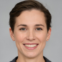 Joyful white young-adult female with short  brown hair and grey eyes