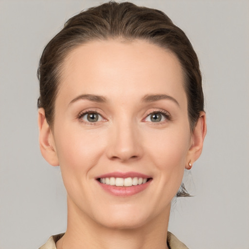 Joyful white young-adult female with short  brown hair and grey eyes