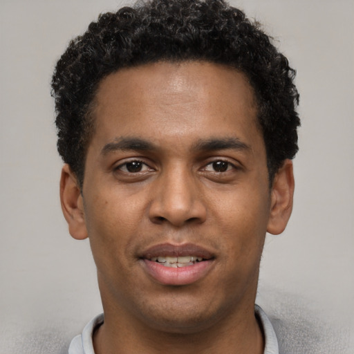 Joyful black young-adult male with short  black hair and brown eyes