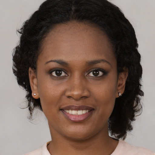 Joyful black young-adult female with medium  black hair and brown eyes