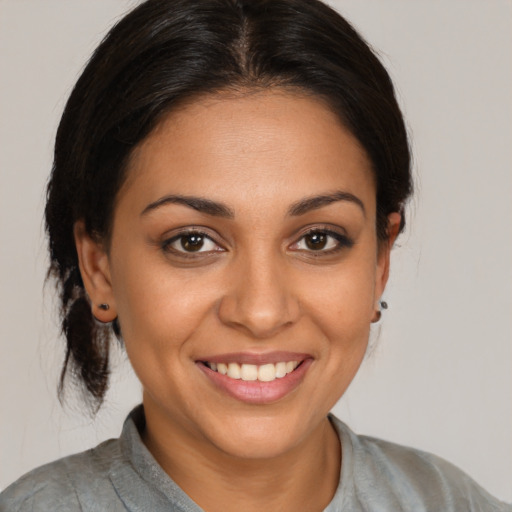 Joyful latino young-adult female with medium  brown hair and brown eyes