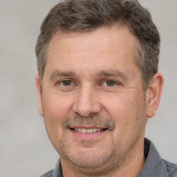 Joyful white adult male with short  brown hair and brown eyes