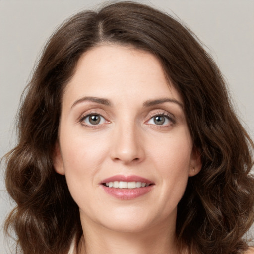 Joyful white young-adult female with long  brown hair and green eyes