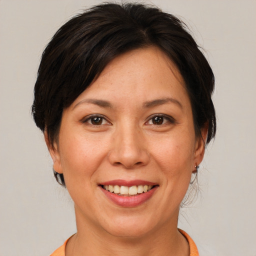 Joyful asian adult female with medium  brown hair and brown eyes
