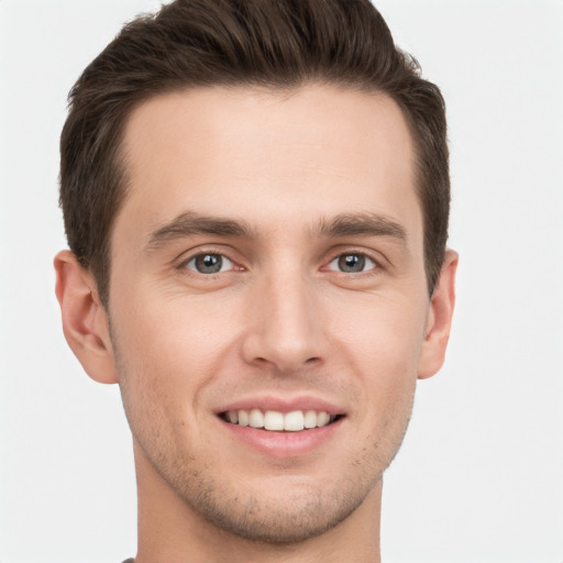 Joyful white young-adult male with short  brown hair and grey eyes