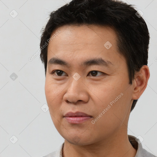 Joyful asian young-adult male with short  black hair and brown eyes