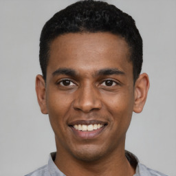 Joyful latino young-adult male with short  black hair and brown eyes