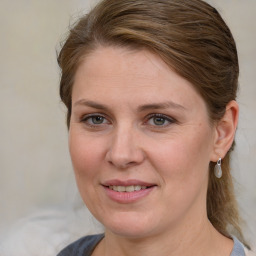 Joyful white adult female with medium  brown hair and blue eyes