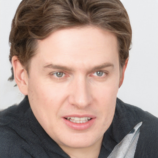 Joyful white young-adult male with short  brown hair and blue eyes