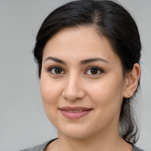 Joyful latino young-adult female with medium  brown hair and brown eyes