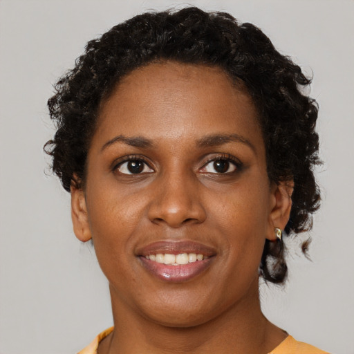Joyful black young-adult female with short  brown hair and brown eyes