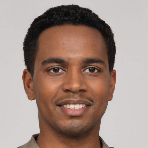 Joyful black young-adult male with short  black hair and brown eyes