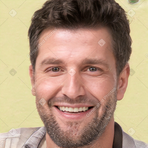 Joyful white adult male with short  brown hair and brown eyes