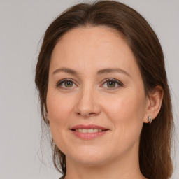 Joyful white adult female with long  brown hair and grey eyes