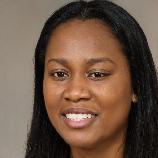 Joyful black young-adult female with long  black hair and brown eyes