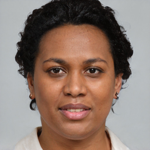 Joyful black adult female with short  brown hair and brown eyes