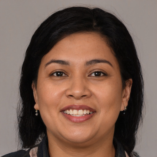 Joyful latino adult female with medium  brown hair and brown eyes