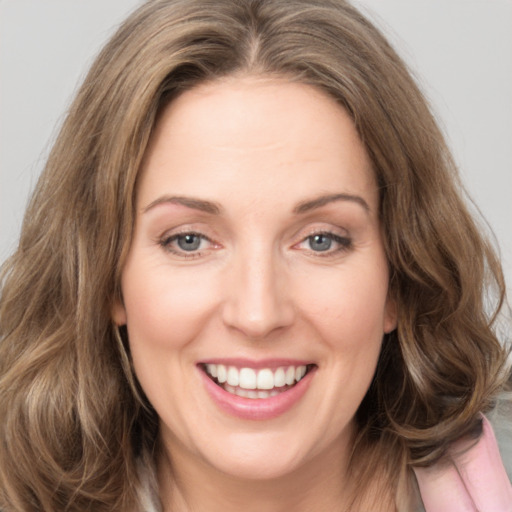 Joyful white young-adult female with long  brown hair and green eyes