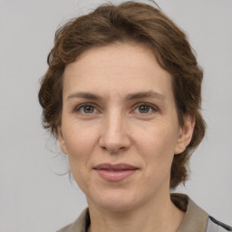 Joyful white adult female with medium  brown hair and grey eyes