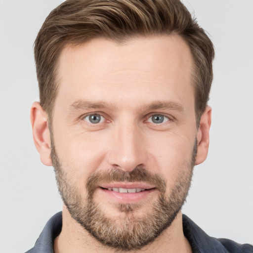 Joyful white young-adult male with short  brown hair and grey eyes