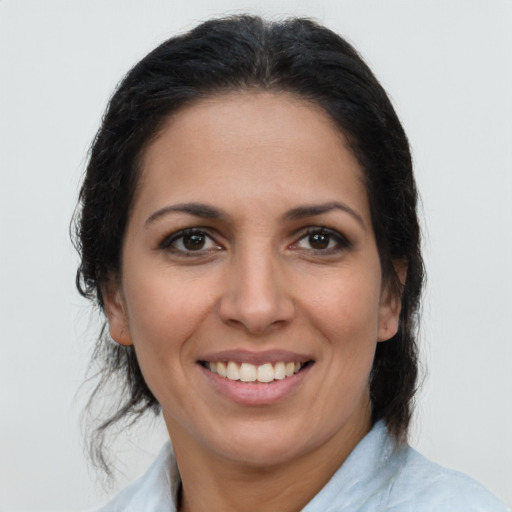 Joyful latino young-adult female with medium  brown hair and brown eyes