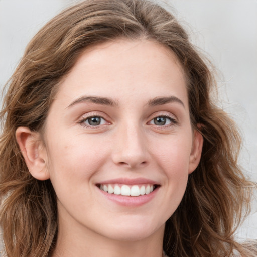 Joyful white young-adult female with long  brown hair and green eyes