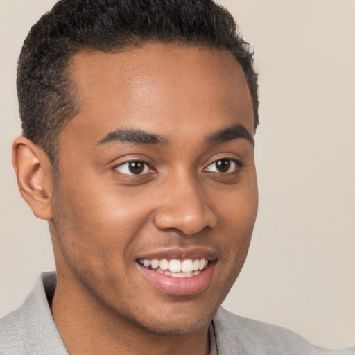 Joyful black young-adult male with short  brown hair and brown eyes