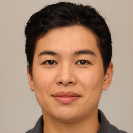 Joyful asian adult male with short  brown hair and brown eyes