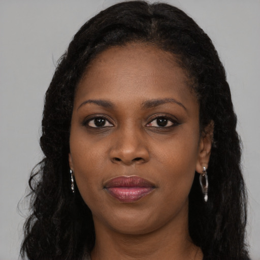Joyful black young-adult female with long  black hair and brown eyes